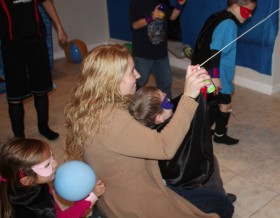 The birthday boy spraying (with a little help from his mom) the evil villain