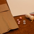 All you need is a paper bag, googly eyes, pink pom pom, two cotton balls, pipe stem, white and two other colors of construction paper and three buttons!