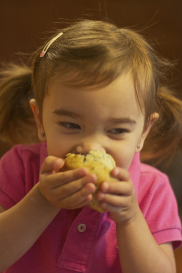 girl eating muffin by learning letter m