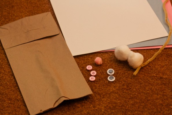 All you need is a paper bag, googly eyes, pink pom pom, two cotton balls, pipe stem, white and two other colors of construction paper and three buttons!